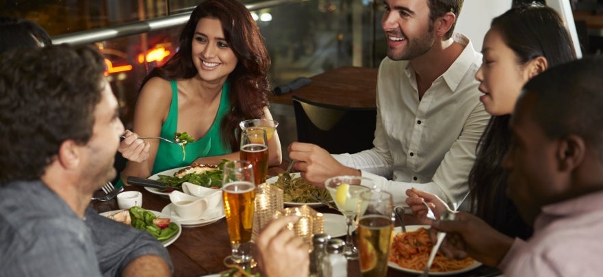 Group Of Friends Enjoying Evening Meal In Restaurant